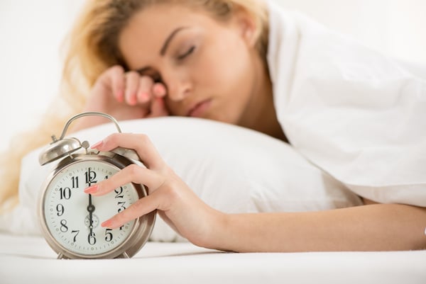 woman waking with alarm clock